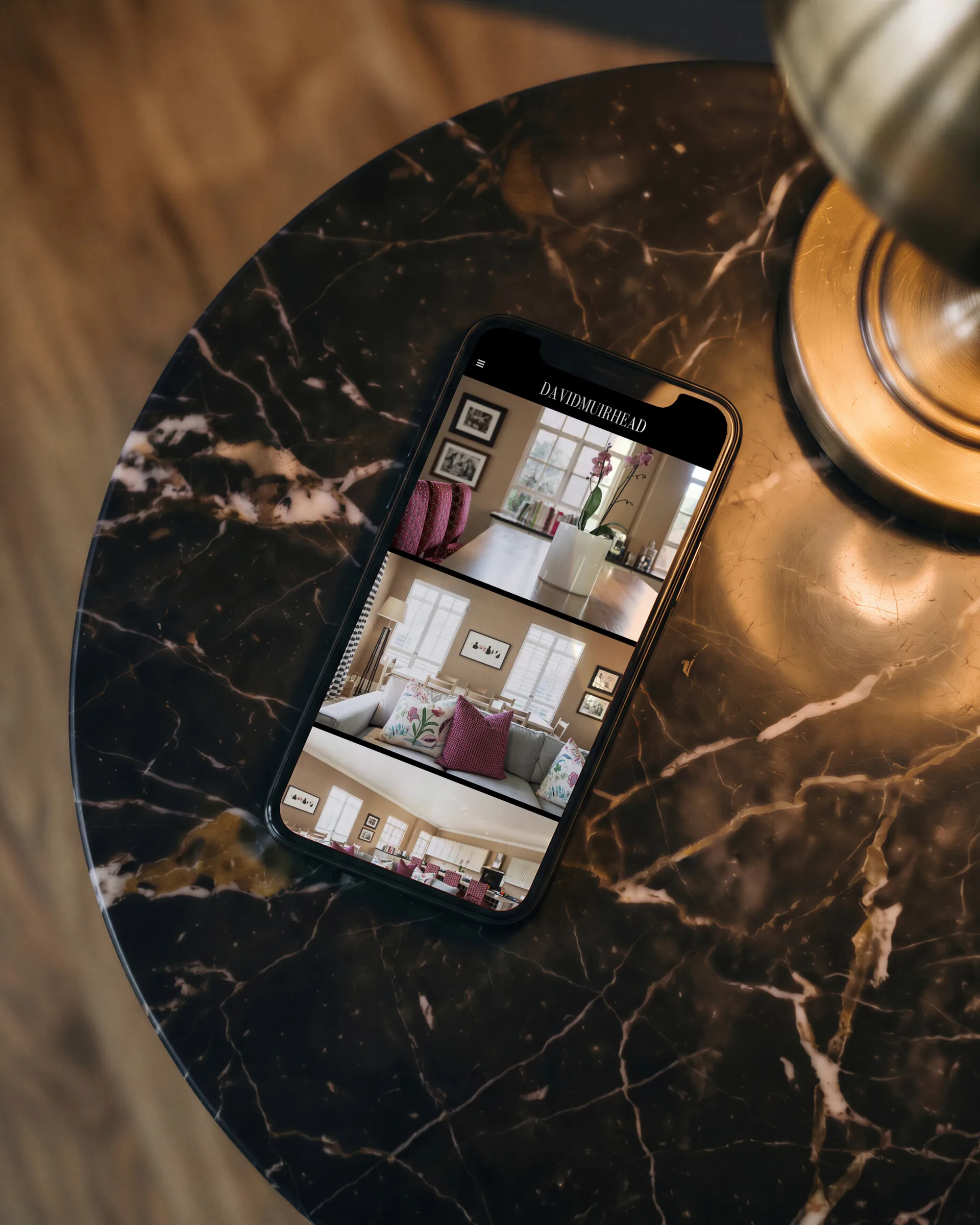 The website on a phone on a marble side table, the whippet on screen.