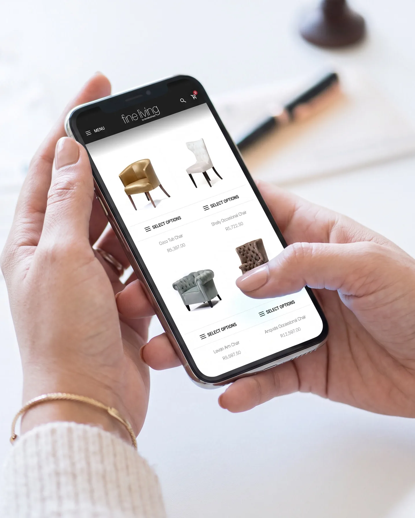 The online shop on a phone in two hands: the chair grid, two to a row.