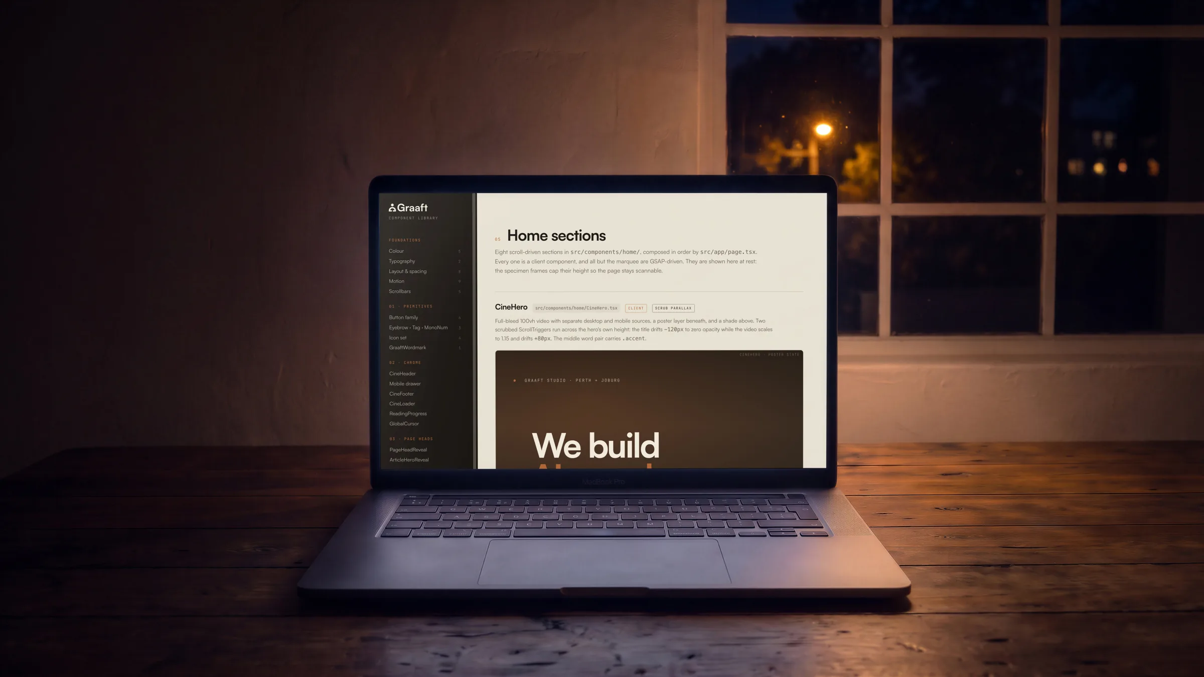 An open laptop square on, on a timber table at night, the component library’s Home sections on its screen.