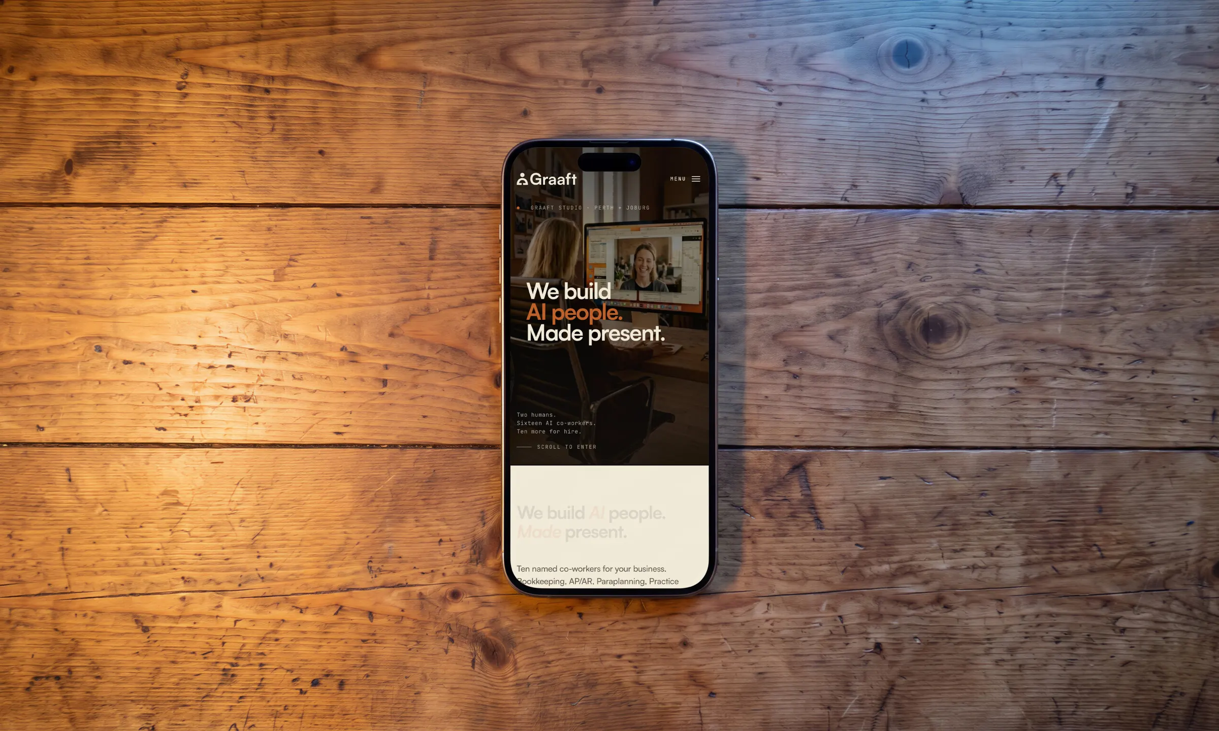 A phone face up on a worn timber table, the home page on its screen.