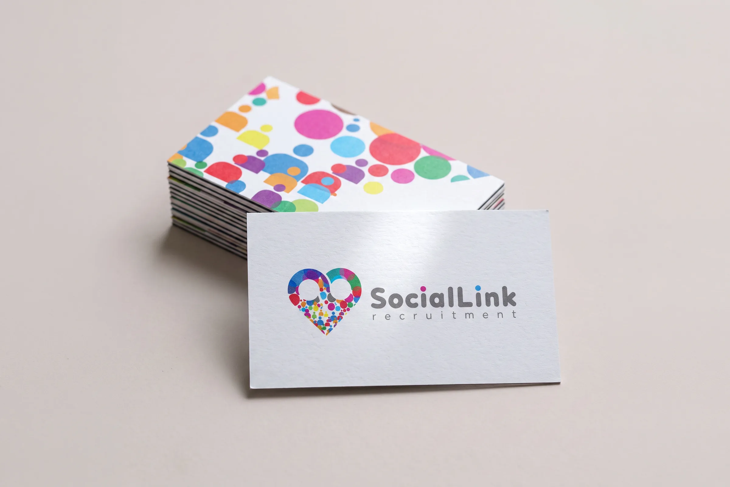 White cards with the heart and grey name, the stack behind showing the scattered-dot reverse.