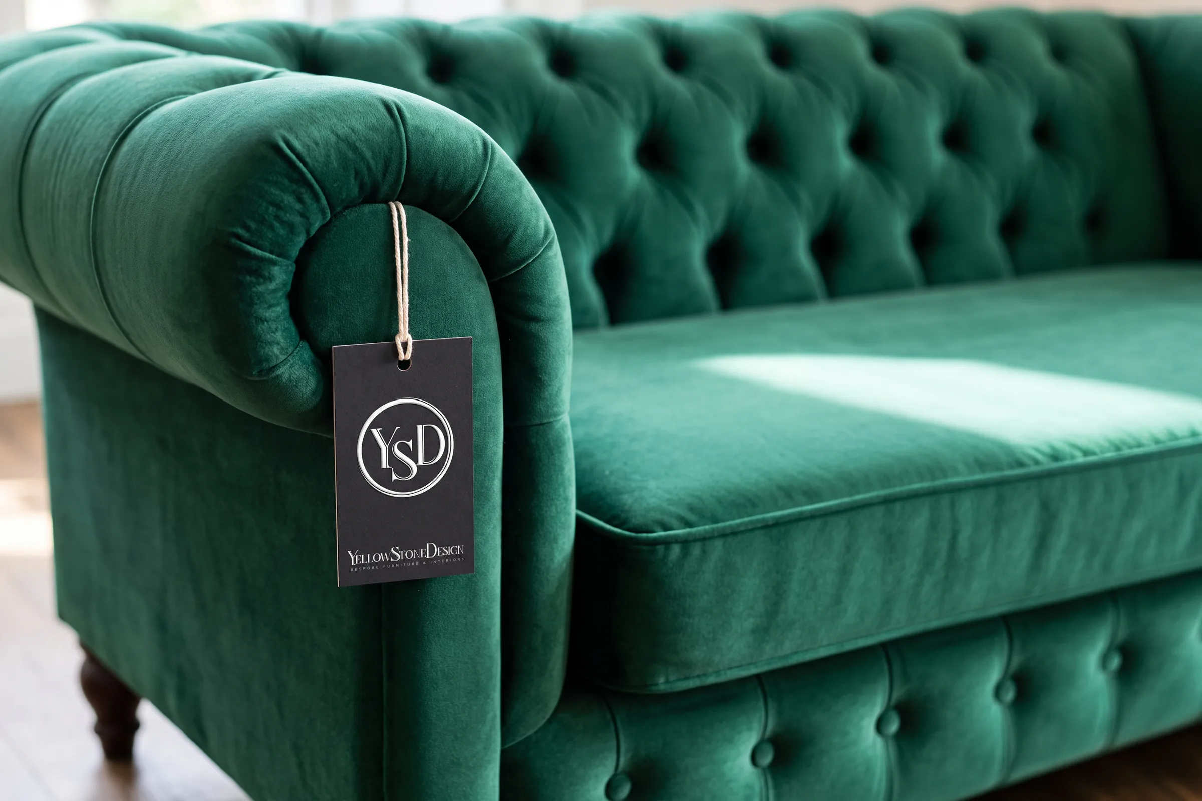 Black business cards and a swing tag on pale marble, the monogram embossed on both.